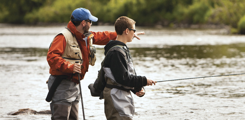 Photo of father and son fly fishing on a river in Vermont